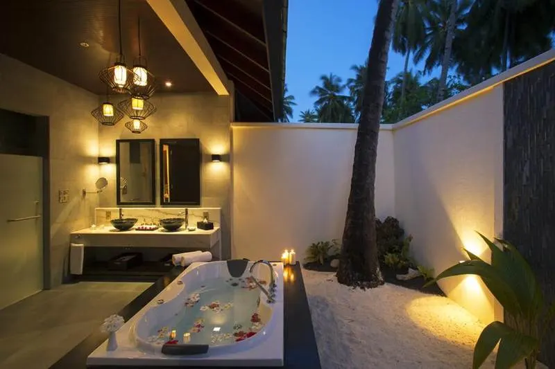 Outdoor bathroom with a stone floor and warm wall lighting
