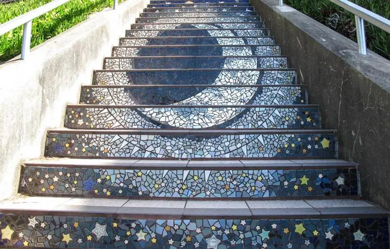 Outdoor stairway decorated with blue and white mosaic risers