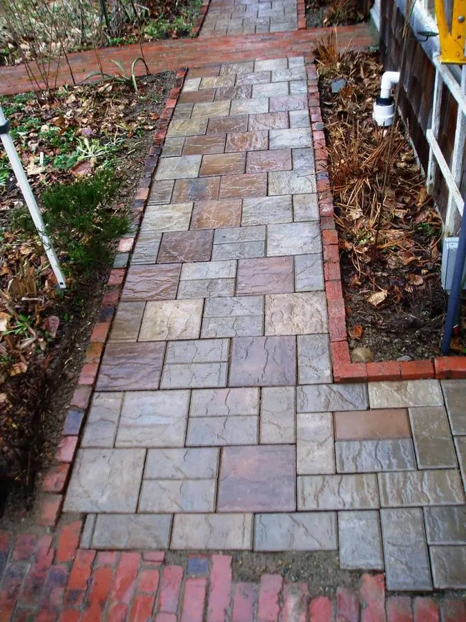 Garden path laid with red, grey and cream rectangular pavers