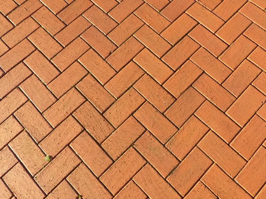 Red-brown rectangular floor tiles laid in a herringbone pattern