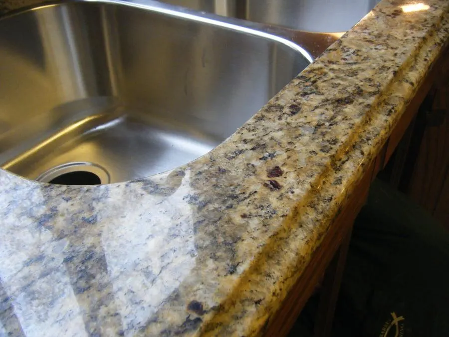 Granite kitchen counter edge beside a stainless steel sink