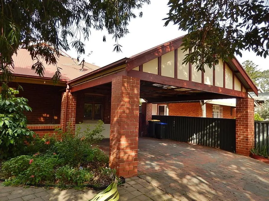 Brick house carport with a wide paved driveway