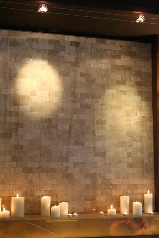 Stone-textured wall tiles illuminated by recessed lights
