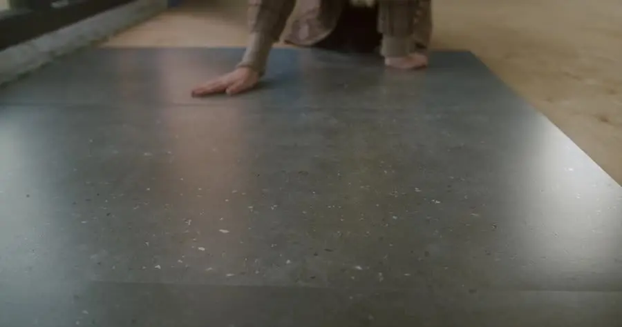 Worker positioning and test-fitting a large-format tile before setting it