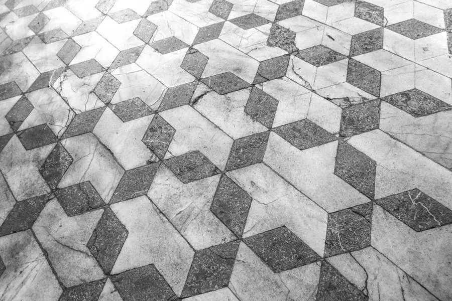 Grey geometric floor tiles arranged in a three-dimensional cube pattern