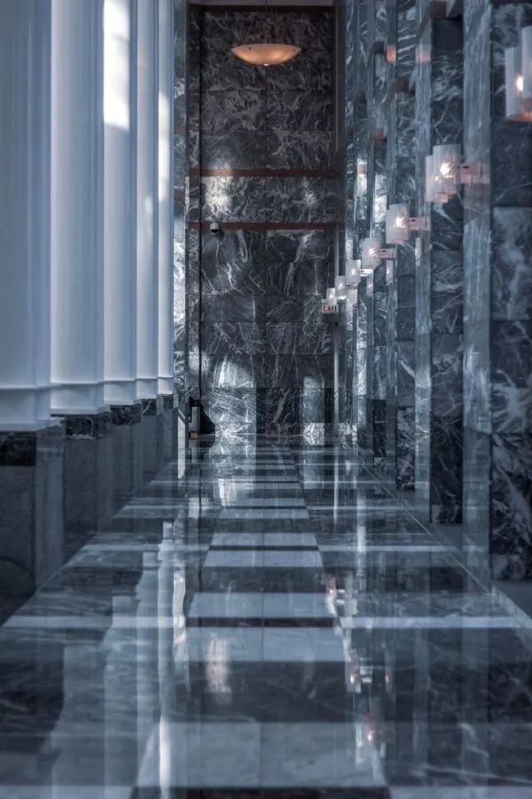 Dark polished stone floor and columns in a corridor
